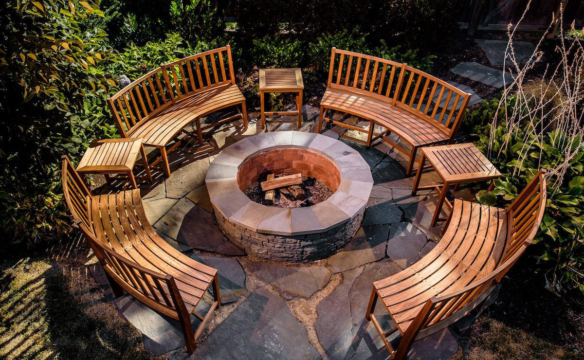 A photo of a hardscaping design with wooden curved chairs